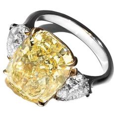 a fancy yellow diamond ring with three diamonds