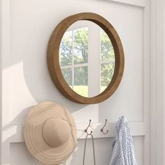 there is a hat on the wall next to a mirror and coat rack with two hats