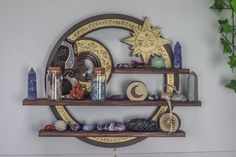 a shelf with various items on it in front of a wall mounted sun and moon