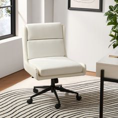 a white office chair sitting on top of a rug in front of a potted plant