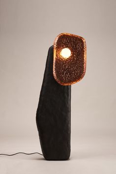 a lamp that is on top of a rock with a light in the middle of it