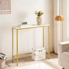 a living room with a white couch and a gold metal console table in the corner