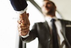 two men in suits shaking hands with each other