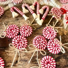 red and white lollipops are tied up on a wooden table with twine