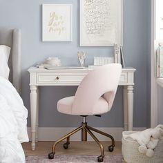 a white desk with a pink chair in front of it and pictures on the wall