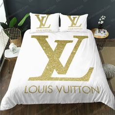 a white bed with gold letters on it and two pillows that say louis vutton