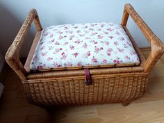 a wicker basket with a cushion on it sitting on the floor next to a wall