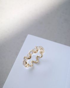 a gold ring sitting on top of a white piece of paper next to a window