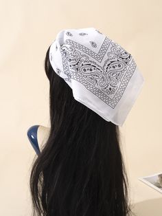 the back of a woman's head wearing a white and black bandanna hat