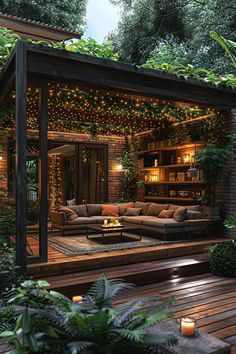 an outdoor living area is lit up with lights and greenery on the roof, surrounded by wooden decking