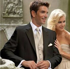 a man in a tuxedo standing next to a blonde woman wearing a white dress