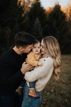 a man and woman holding a baby in their arms