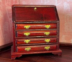 a small wooden desk with drawers and knobs