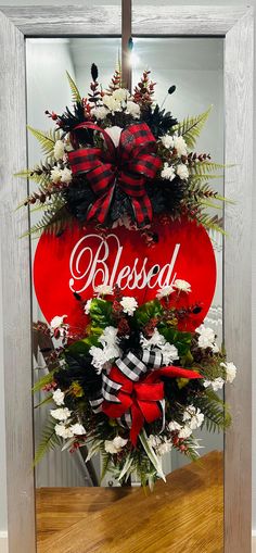 a christmas wreath with the word blessed on it in front of a wooden framed frame