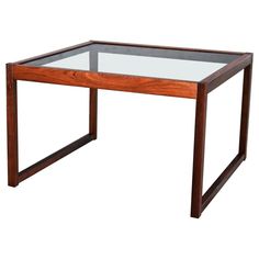 a wooden table with glass top and metal frame on the bottom, against a white background