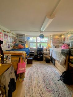 a bedroom with two beds and a rug on the floor in front of it is full of clutter