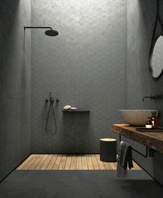 a bathroom with a wooden floor and white walls, along with an open shower stall