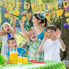 a group of kids standing around a table with orange juices and drinks in front of them