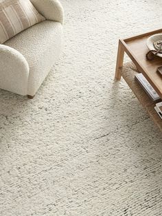 a living room with a couch, coffee table and chair on the carpeted floor