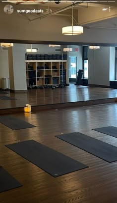 an empty room with yoga mats on the floor