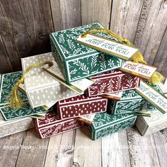 a pile of christmas gift boxes sitting on top of a wooden floor next to each other