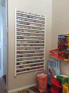 a child's play room with toys on the floor and shelves full of cars