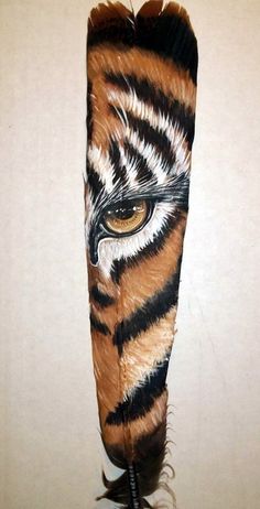 an animal's eye is shown on the side of a piece of feathers that has been painted