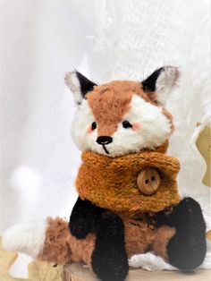 a stuffed fox with a scarf around it's neck