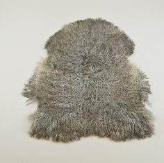 a gray furry animal rug on a white background with room for text or image to be added