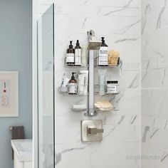 a bathroom with white marble walls and shelves holding personal care items, such as toiletries and soaps