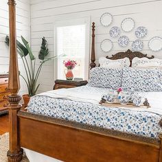 a bed sitting in a bedroom next to a wooden dresser and mirror on the wall