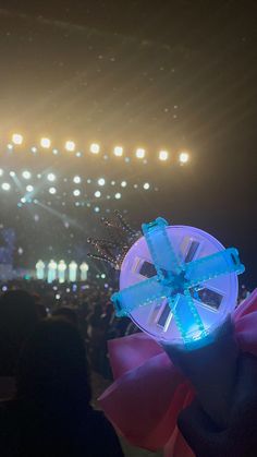 a person holding up a plastic object in front of an audience at a music concert