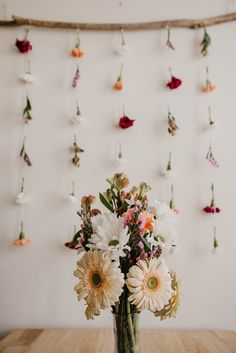 a vase filled with flowers sitting on top of a wooden table