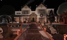 a large white house with christmas lights on it's front yard and walkway leading to the entrance