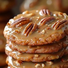 a stack of cookies covered in frosting and pecans on top of each other