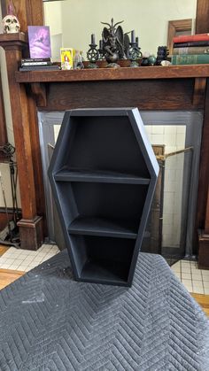 an open book shelf sitting on top of a bed in front of a fire place