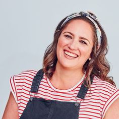 a smiling woman wearing overalls and a bandana