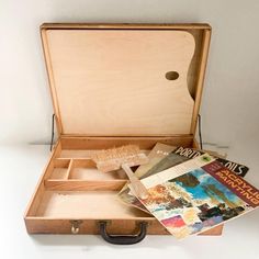 an open suitcase with various items in it on a table next to a white wall