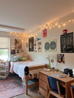 a dorm room with lights strung over the bed and desks in front of it