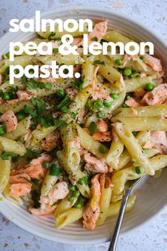 salmon, pea and lemon pasta in a white bowl with a spoon on the side