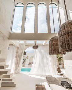 the interior of a house with white walls and ceiling, covered in sheer fabric curtains