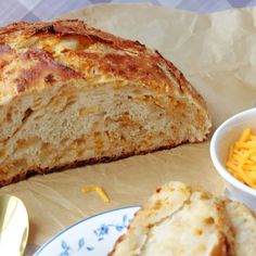 a loaf of bread next to a bowl of macaroni and cheese