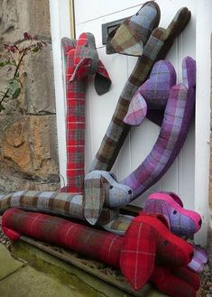 three stuffed animals are hanging on the front door with their heads turned to look like they have been made out of fabric