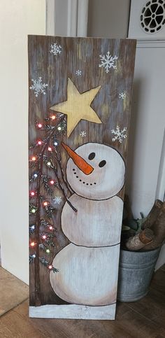 a painting of a snowman with a star on his nose and a christmas tree in front of it