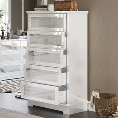 a white dresser with marbled drawers in a room next to a basket on the floor