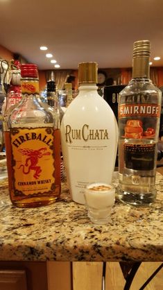 bottles of rumchata sit on a counter in a bar with other liquors