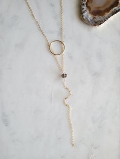 Beautiful and dainty Smoky Quartz Y Necklace. A perfect necklace for fall that you can easily dress up or down. It can be worn with a V neck as shown or over a top. The circle is hammered for texture and shine. The length of the drop from the top of the circle down to the bottom of the chain is 6 in. The length of the necklace shown in the picture is 17 in. That length is the chain around the neck to the top of the circle. Smoky Quartz is a natural stone and may vary slightly in color from dark rich brown to a light brown. If you have a preference, message or leave me a note and I will do me best to accommodate. Thank you! Smoky Quartz, Earring Necklace, Gold Filled, Natural Stones, Chain, Stone, Gold