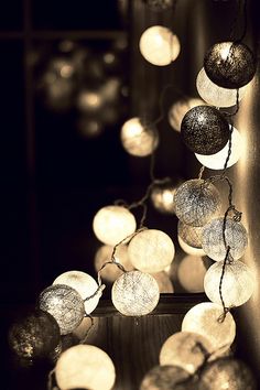 a bunch of lights that are hanging from the side of a wall in black and white