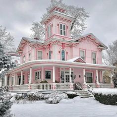 a large pink house is covered in snow