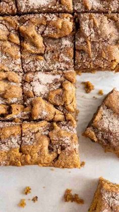 several pieces of brownie with powdered sugar on top and one slice cut out